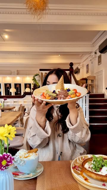 A promotional video for 'Bruncho' in Leeds, showcasing the interior, various brunch dishes including French toast and Turkish eggs, and a selection of pastries and drinks.