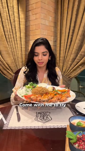 A video review of Samad Al Iraqi restaurant in Kensington, London, featuring a variety of traditional Iraqi dishes including lamb chops, kebabs, grilled shrimp, and kunafa. The creator provides a walkthrough of the dining experience, highlighting the food quality and the restaurant's ambiance.