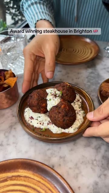 A fast-paced review of Kindling, an award-winning steakhouse in Brighton, highlighting their charcoal-grilled beef, small plates, and overall dining experience.