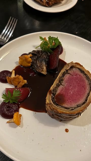 A montage showcasing a high-end dining experience at One Devonshire Gardens, featuring tableside carving of a Beef Wellington, bread service, scallops, tomato salad, and dessert.
