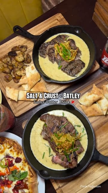A promotional video for Salt & Crust in Batley, featuring their Swiss Butter Steak and stone-baked pizzas. The video uses a montage of interior shots and close-ups of the food, set to music with text overlays describing the dishes.