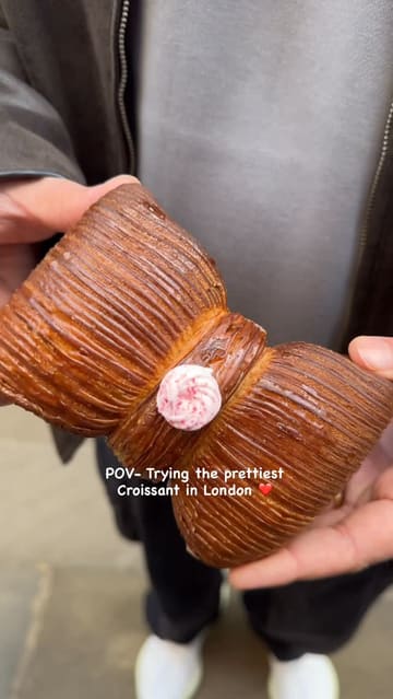 A short video showcasing a unique bow-shaped croissant from Sourdough Sophia in London. The video features close-up shots of the pastry's exterior and a cross-section reveal of the filling.
