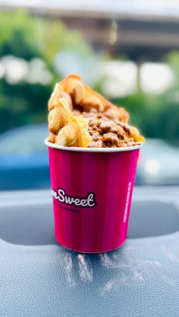 A short video showcasing a visit to a dessert drive-thru, highlighting the ordering process and the various sweet treats purchased, including churros, cookie dough, waffles, and sundaes.