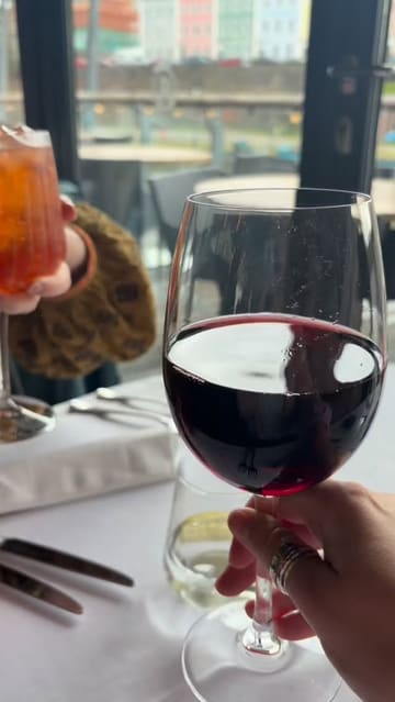 A short, music-led montage showcasing a Sunday lunch experience at Riverstation in Bristol, featuring close-ups of drinks, starters like pate and tomatoes, and a hearty Sunday roast with cauliflower cheese, set against a waterside backdrop.