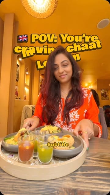 A creator visits 'Keep Chaating' in London, showcasing their chaat platter which includes pani puri, dahi puri, and samosa chaat. The video features the exterior, interior, and the act of eating the food, presented in a fast-paced, music-driven vlog style.