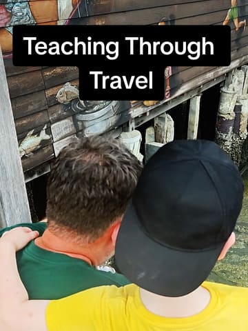 A family travel vlog featuring a walk along the Chew Jetty in Georgetown, Penang. The video captures the father and son observing the local architecture, specifically the wooden stilts and the street art painted on the side of the buildings over the water.