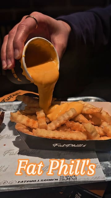 A short, fast-paced video showcasing burgers, fries, and cheese sauce at Fat Phill's in Dublin, featuring close-up shots of the food being prepared and eaten.