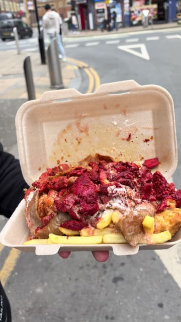 A creator reviews a takeaway meal from Khyber Diner in Sheffield, comparing it to a previous experience at a nearby competitor. He walks through the meal components, including chicken, donner meat, chips, and wedges, providing commentary on the taste and quality while standing outside the venue.