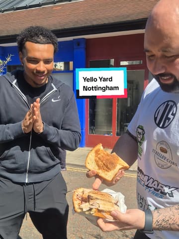A creator reviews a Caribbean/Jamaican street food spot called Yello Yard in Nottingham. He samples a jerk pork sandwich, discusses the sauce, and interviews the owner who shows a large pot of the marinade.
