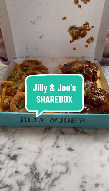 A short promotional video showcasing a new 'Deluxe Sharebox' from Jilly & Joe's food truck. The video features shots of the truck, the outdoor seating area, and a close-up reveal of the food platter, which includes wings, ribs, onion rings, and chips.