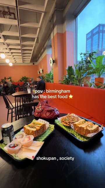 A short, energetic video featuring a visit to Shokupan in Birmingham, focusing on their signature katsu-style sandwiches and fries within a modern, casual dining environment.