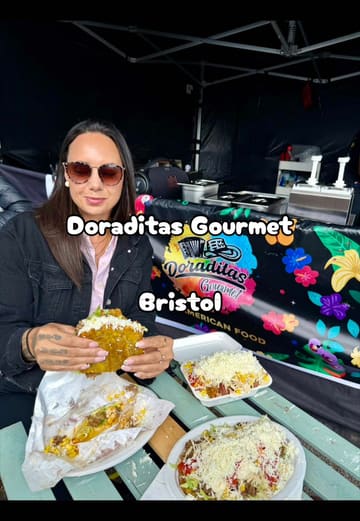 A food blogger reviews various Colombian street food dishes from a market stall called Doraditas Gourmet, highlighting the authenticity and portion sizes.