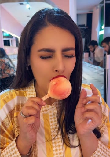 A short, energetic taste test video featuring a creator visiting Snowflake Gelato in London to compare different gelato flavours, specifically a peach-shaped gelato and a chocolate-covered gelato bar.