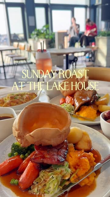 A montage video showcasing a Sunday roast meal at The Lake House, featuring close-ups of various roast meats, sides, desserts, and drinks, alongside shots of the venue's interior and live music.