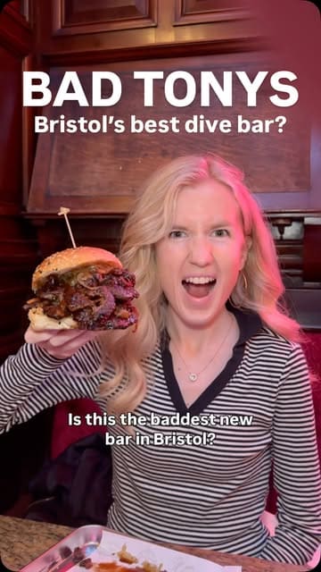 A vlog-style review of a new bar in Bristol called Bad Tony's, showcasing their mezcal cocktails, affordable snacks like corn dogs, smash burgers, and fried chicken.