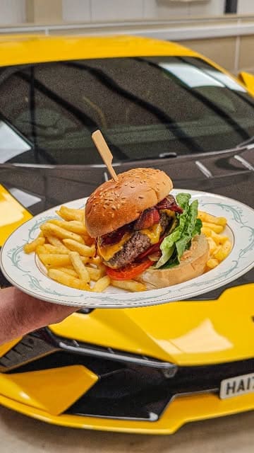 A promotional reel for Bobbie's Garage Diner, located within Concours House. The video showcases the unique venue, which allows diners to eat surrounded by a collection of supercars. It highlights the menu, including a burger and avocado toast, and mentions upcoming events at the venue.