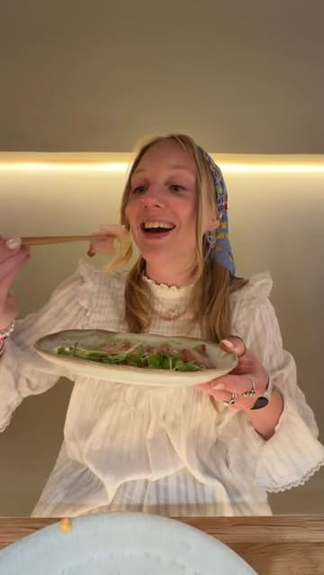 A vlog-style review of a handroll bar in Mayfair, featuring the creator and a friend trying various sushi dishes, including temaki, sashimi, and wagyu sliders.