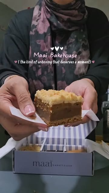 A short, focused unboxing video of a box of assorted baked goods from Maai Bakehouse, highlighting the packaging and the variety of items included.