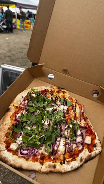 A short, fast-paced video capturing the preparation and final presentation of wood-fired pizzas from Dough & Co at a food festival. The reel features shots of the menu, the pizza-making process, and the finished products.