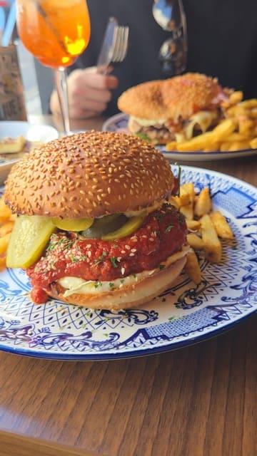 A creator visits Clydee's in Brighton to review their Korean-style burgers, showcasing the food preparation, the venue's atmosphere, and the owner.