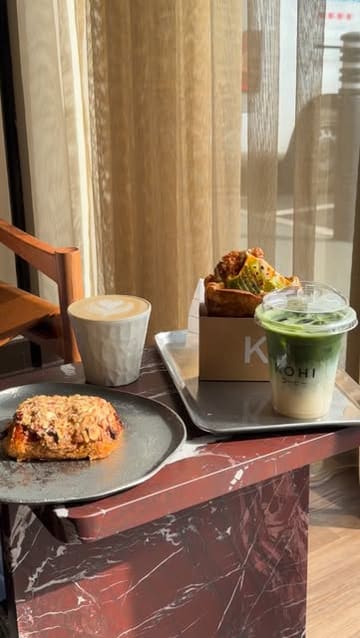 A montage showcasing the interior, drinks, and food at Kohi cafe, featuring a flat white, iced matcha, hazelnut pain au chocolat, and a chicken sando.