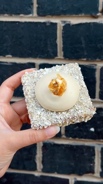 A short, handheld-style video showcasing a popcorn-themed pop-up patisserie. It features close-up shots of various pastries, including a popcorn magnum, cookies, lamingtons, and a savoury danish, as well as a jasmine tea with cold foam.