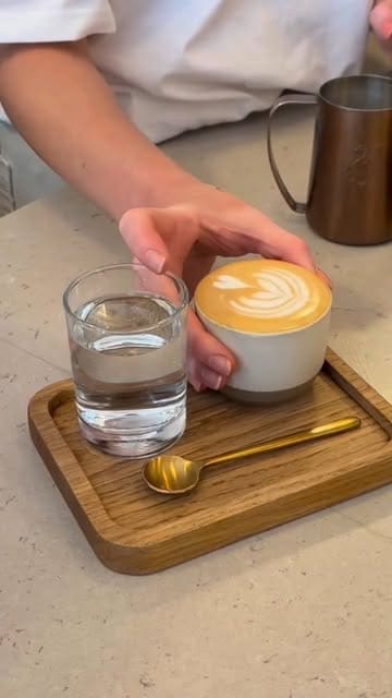 A short, aesthetic montage showcasing a specialty coffee shop, featuring close-ups of pastries, a menu board, latte art, and banana bread with melting butter.