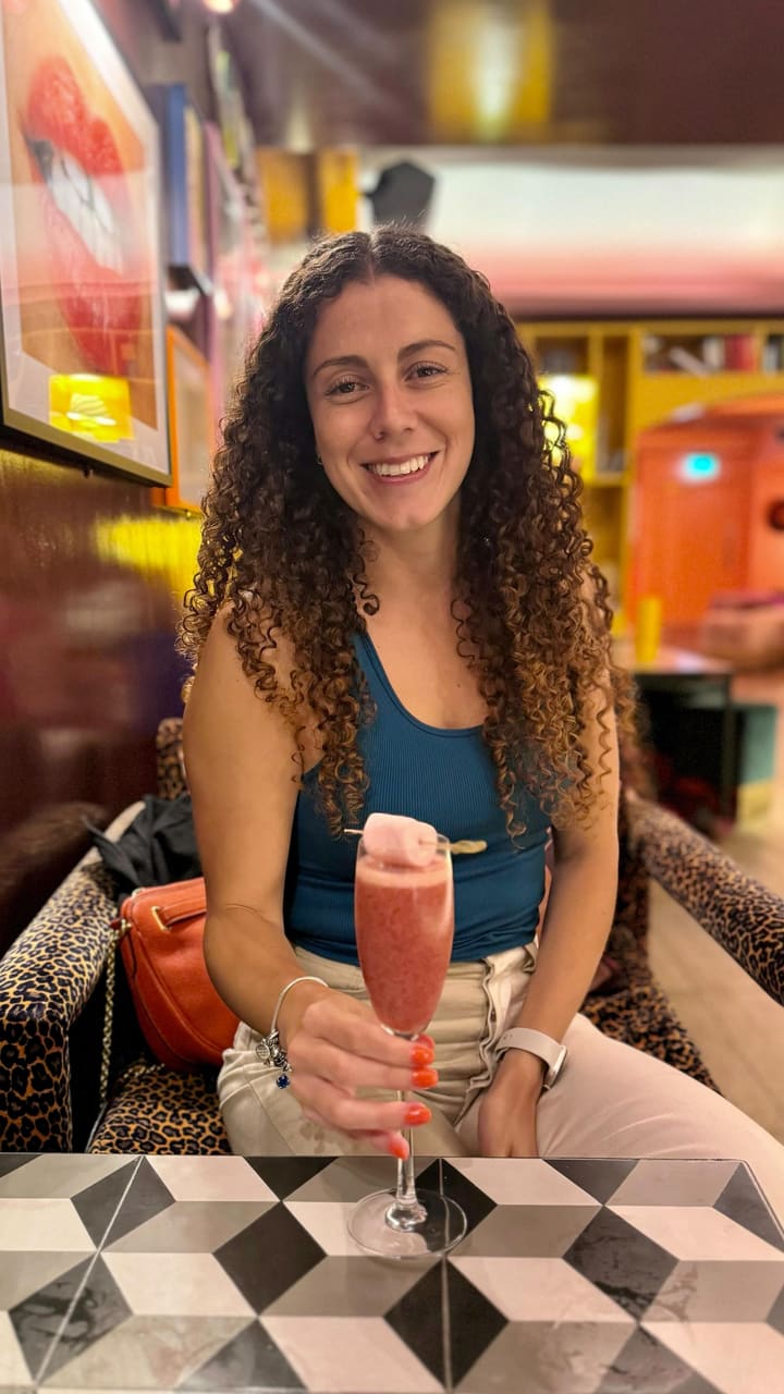 The video showcases The Little Violet Door, a bar in Soho, London.  It features various cocktails (including one served in a can), bar snacks like a chicken sandwich and fries, and glimpses of the bar's interior, which is eclectic and vibrant. The presentation emphasizes the fun and lively atmosphere. No dietary information is explicitly provided.