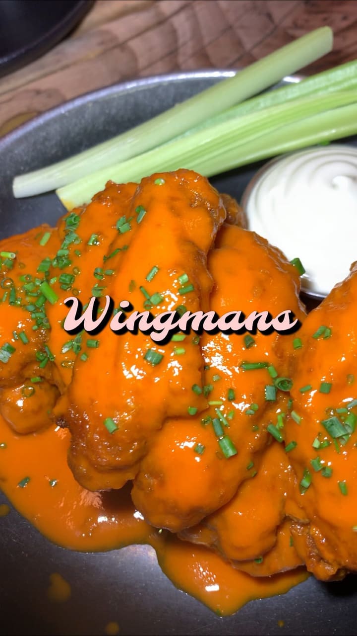 This video showcases Wingmans, a restaurant in Kilburn, offering a Wing Wednesday deal. It features various dishes including signature wings with different sauces, truffle mac and cheese with slow-roasted beef, cheesy fries, and a chocolate cookie dough dessert.  The video highlights generous portion sizes and visually appealing food presentation. The overall tone is highly positive and enthusiastic.