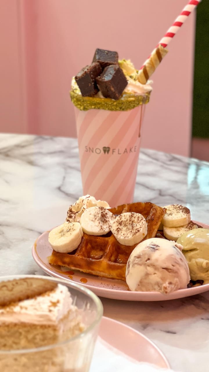 The video showcases Snowflake Gelato in Soho, London. It features three desserts: a milk cake with Lotus biscuits, banoffee waffles with gelato, and a pistachio brownie sundae milkshake. The presentation is visually appealing, with close-up shots highlighting textures and colors. No dietary information is explicitly mentioned. The main focus is a delicious dessert showcase.