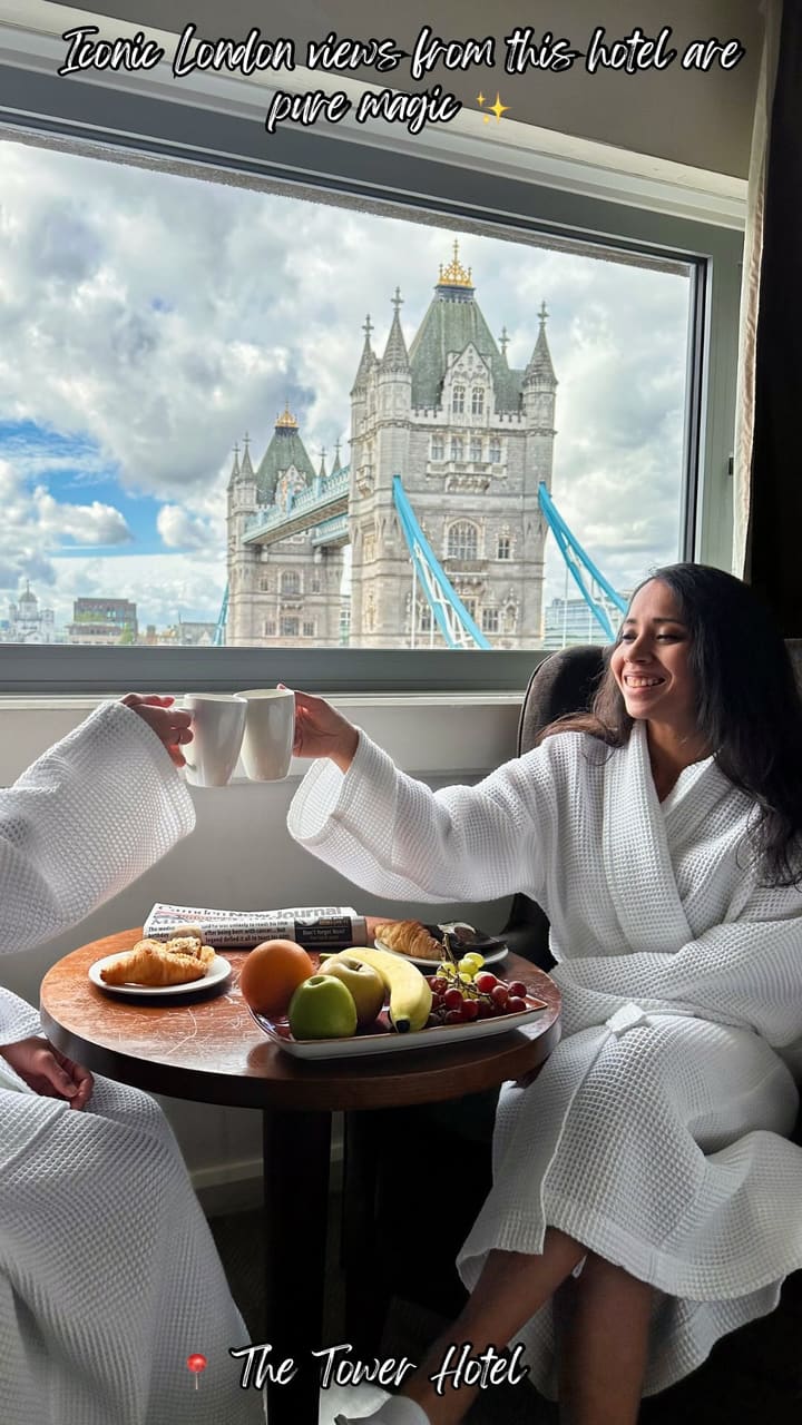 The video showcases a luxurious breakfast experience in a hotel room with a direct, clear view of London's Tower Bridge. It features two people in white robes enjoying coffee, pastries, and fresh fruit at a table set by a large window. The video consists of several clips showing the breakfast spread, the people toasting with their mugs, and enjoying the scenic view, all set to upbeat, positive music.