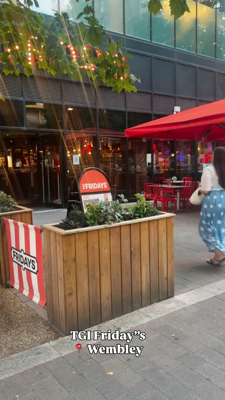 A creator visits a TGI Fridays location, showcasing a variety of menu items including nachos, onion rings, quesadillas, wings, a pasta dish, a chicken and rice dish, and a sundae. The video uses quick cuts and upbeat music to present the dining experience.