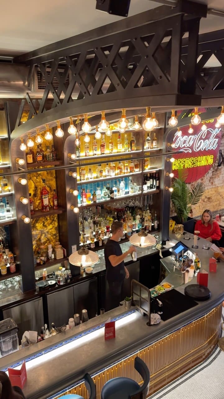The video showcases a meal at Maxwell's Bar & Grill in Covent Garden, London.  The food includes nachos with chicken, baby back ribs with chips and coleslaw, grilled salmon with potatoes, and for dessert, a strawberry sundae and a brownie with ice cream. Drinks shown are cocktails and milkshakes. The presentation is visually appealing, with close-ups emphasizing textures and colors.  No specific dietary information is provided. The main focus is on showcasing the food and drinks at this restaurant.