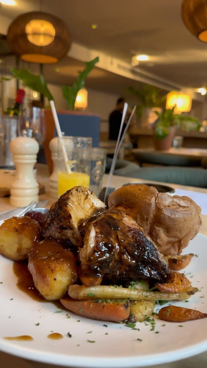 The video showcases a Sunday roast dinner at No35 Mackenzie Walk, a restaurant in Canary Wharf. It features various dishes, including a mixed roast (beef, pork belly, chicken), buttermilk fried chicken tenders, crispy squid, braised leek and cheddar croquettes, smoked aubergine and chickpea dip, and sticky toffee pudding.  The food is presented attractively, with close-up shots emphasizing textures and colors.  No specific dietary information is provided.
