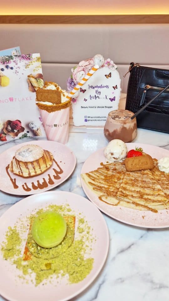 The video showcases Snowflake Gelato, a cafe in London's Soho.  It features various desserts and drinks, including an Oreo crumble doughnut, Lotus Biscoff crepe, a limited-edition pistachio tennis ball dessert (Wimbledon themed), a Lotus Biscoff sundae, and an iced chocolate. The presentation focuses on visually appealing arrangements with pastel-colored plates and a pink theme.  No specific dietary information is provided. The main focus is a meal showcase.