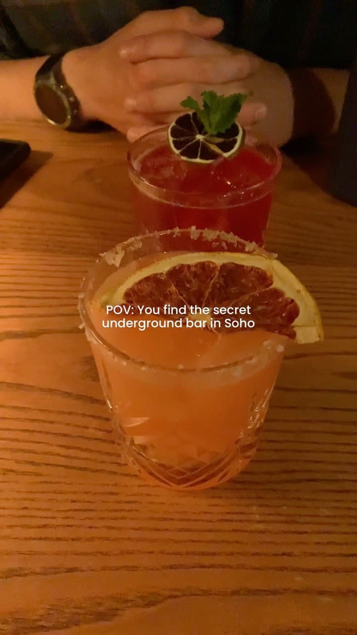 The video showcases Ember Bar, a hidden bar located beneath the Ember Yard restaurant in Soho, London. It highlights the process of cocktail making, featuring various colorful cocktails, including one called the 'Ember Garden.' The video emphasizes the ambiance of the underground bar, the cocktails' presentation, and the overall experience of visiting this unique venue.  The bar is described as a perfect place to dress up and go with friends. 
