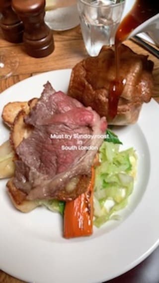The video showcases a Sunday roast at The Cyclist pub in Balham, South London.  It features various dishes including roast beef, roast chicken, pork belly, Yorkshire pudding, roast potatoes, cauliflower cheese, and gravy.  The food is presented on white plates, with close-ups highlighting textures and colors.  The video doesn't explicitly mention dietary options. The main focus is on the visual appeal and deliciousness of the Sunday roast.