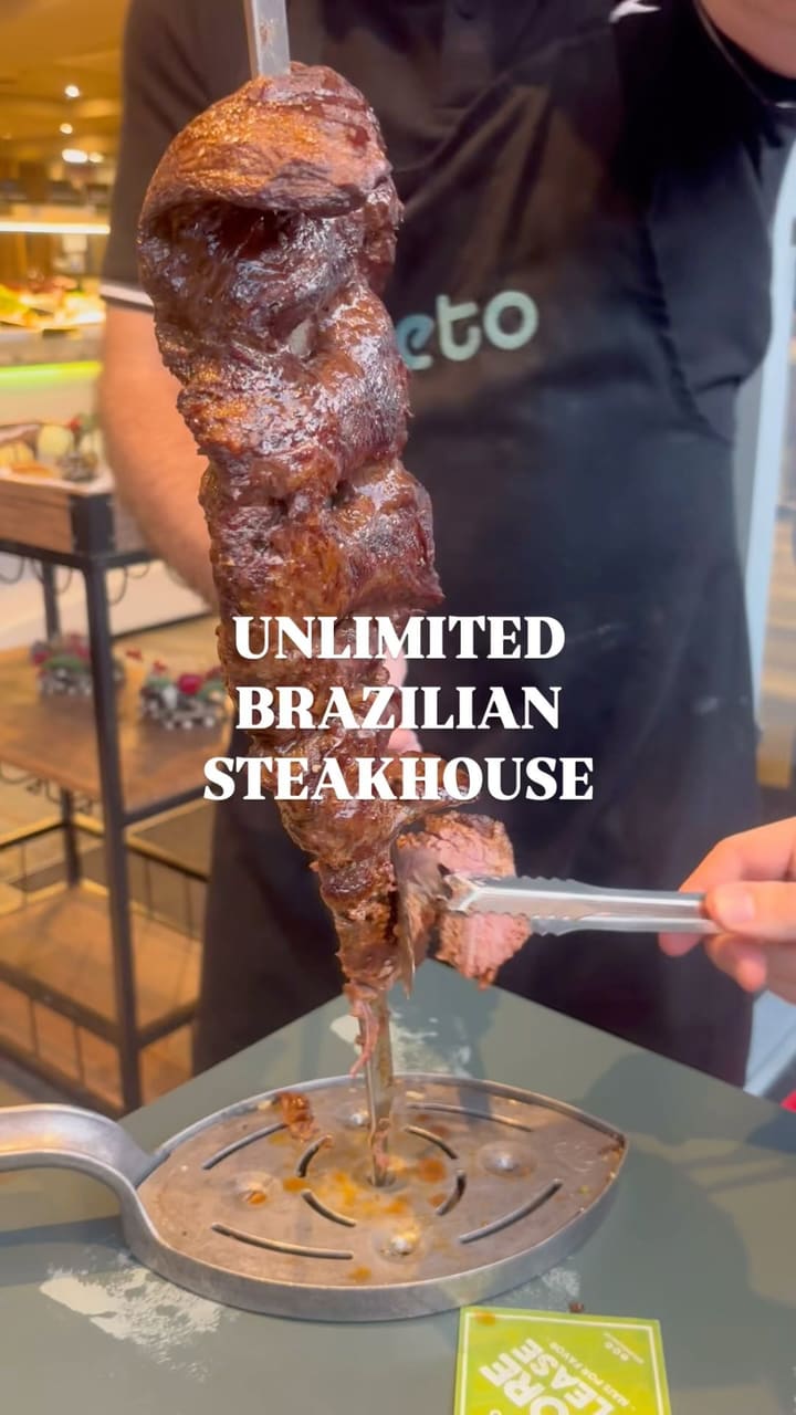 The video showcases a Brazilian steakhouse experience. It features unlimited spit-roasted meats, including beef and chicken, carved directly at the table by staff. It also highlights a salad buffet bar with various side dishes like mixed rice, fried bananas, salads, and croquettes. The video shows a jug of caipirinha and a slice of dulce de leche cheesecake. It explains the restaurant's system using green and red cards to signal for more meat or to stop.