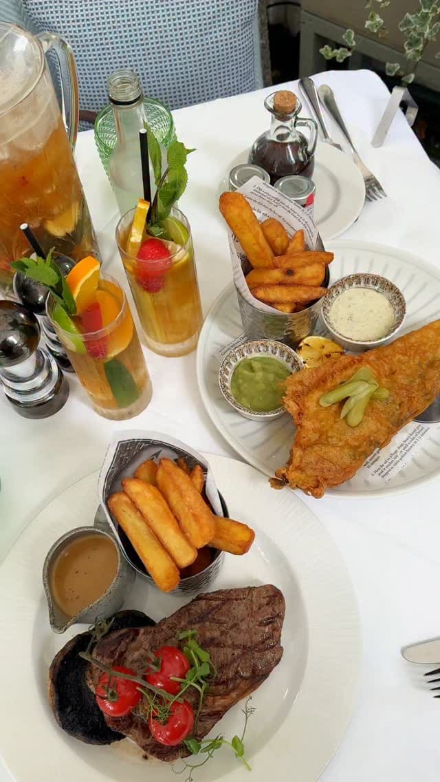A promotional video for the restaurant at The Royal Horseguards Hotel in London. It showcases the outdoor terrace setting. The food featured includes fish and chips, a ribeye steak with chips and sauce, and an Earl Grey panna cotta for dessert. Drinks shown are a jug and glasses of Pimm's. The video includes close-ups of the food being cut and eaten, highlighting its texture and quality, as well as shots of the menu and the general ambiance of the terrace.