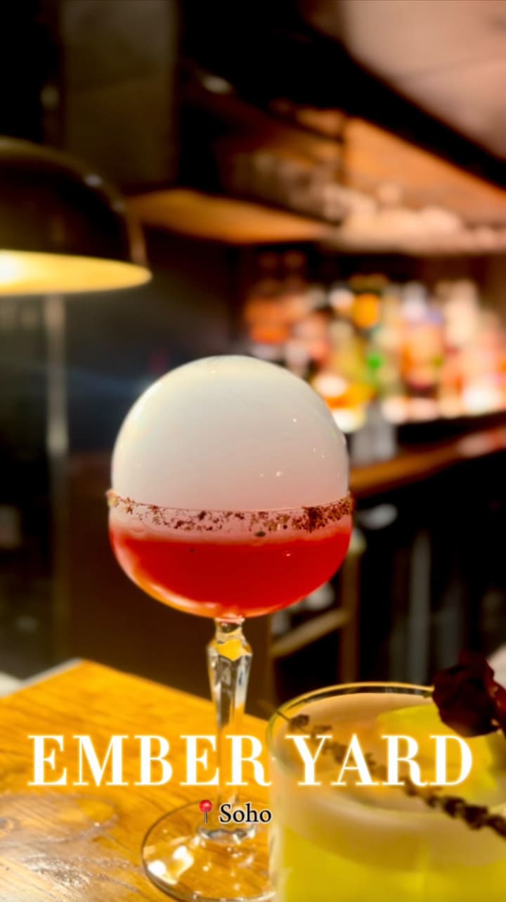 The video showcases Ember Yard, a restaurant with a hidden cocktail bar. It features various cocktails: a smoke-infused hibiscus margarita, a classic Negroni, a Passion Yard, an Ember Garden, and a bartender's special.  The cocktails are presented in stylish glassware with garnishes.  The video also briefly shows a bowl of mixed nuts and a fried zucchini flower dish. The main focus is the cocktails, highlighting their unique presentation and the bar's ambiance.