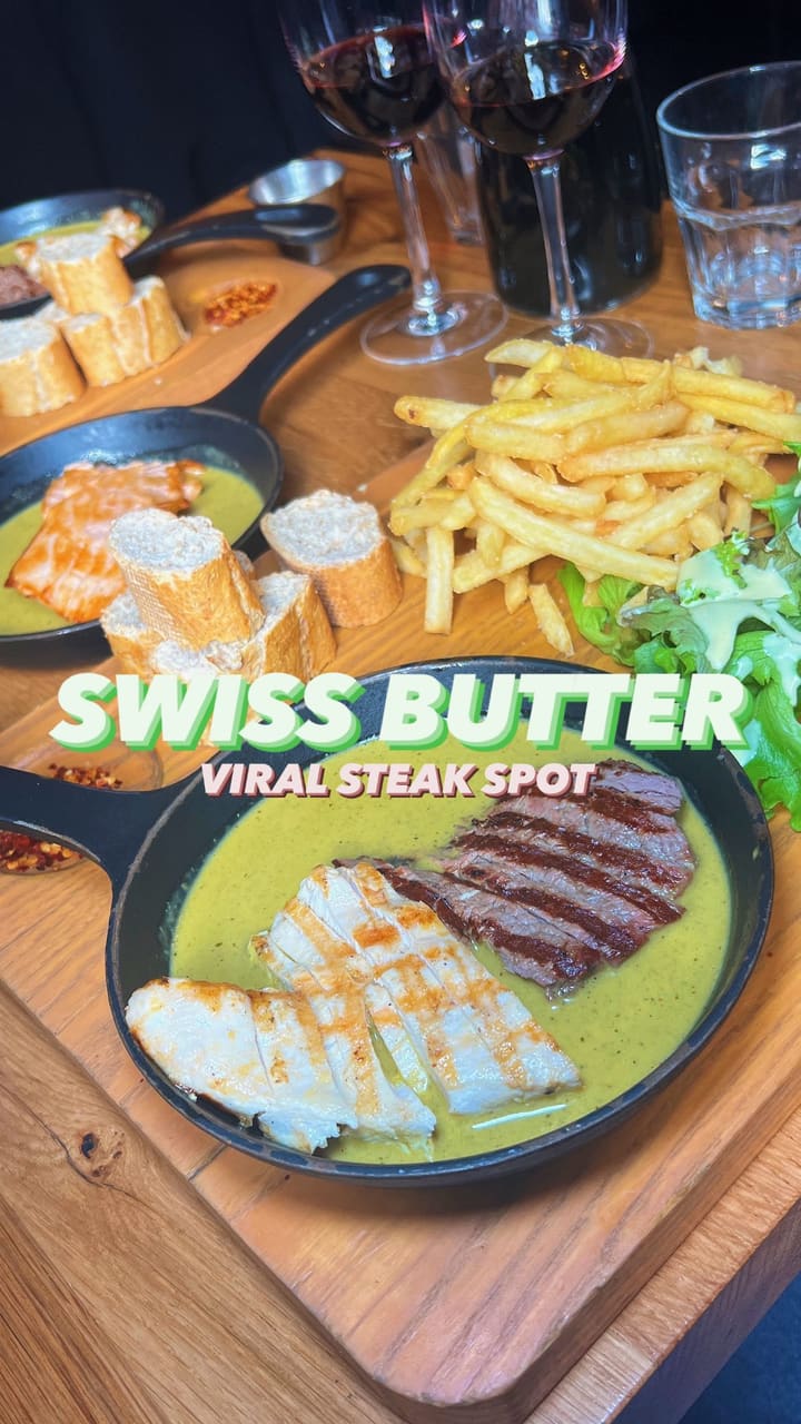 This video showcases Swiss Butter restaurant in London. It highlights a steak board with a unique butter sauce, along with sides like fries, salad, and bread. The desserts shown are a chocolate lava cake and a dessert resembling a creme brûlée. The video is primarily focused on showcasing the food and restaurant ambience.