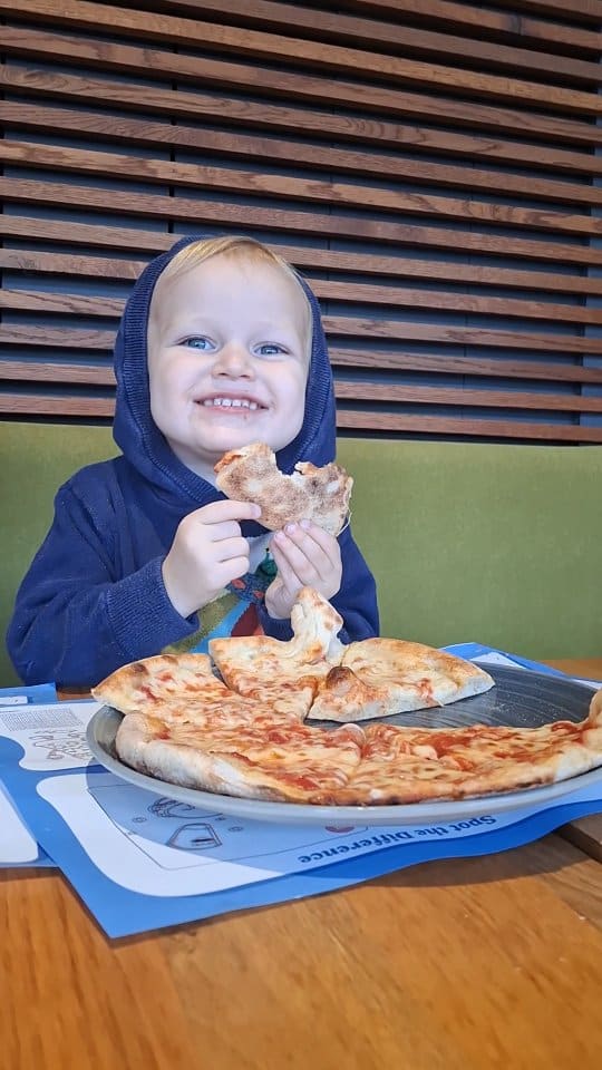 A montage video showcasing a family with young children dining at a Prezzo Italian restaurant. The video captures the kids engaging with activity menus and 3D glasses, and enjoying their meals. The food featured includes cat-shaped margherita pizzas, spaghetti, rigatoni, french fries, and ice cream. The overall focus is on the family-friendly atmosphere and the food offerings.