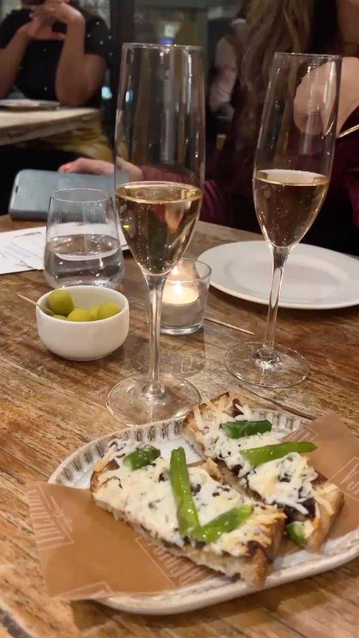 The video showcases a wine tasting event at Iberica Restaurants in London. It features various Spanish wines, including sparkling and rosé, paired with tapas-style dishes like asparagus toast and croquetas. The restaurant's ambiance is also highlighted, showing both the dining area and the bar. The presentation focuses on the food and drinks, with some shots of the people enjoying the event. No dietary information is explicitly mentioned.