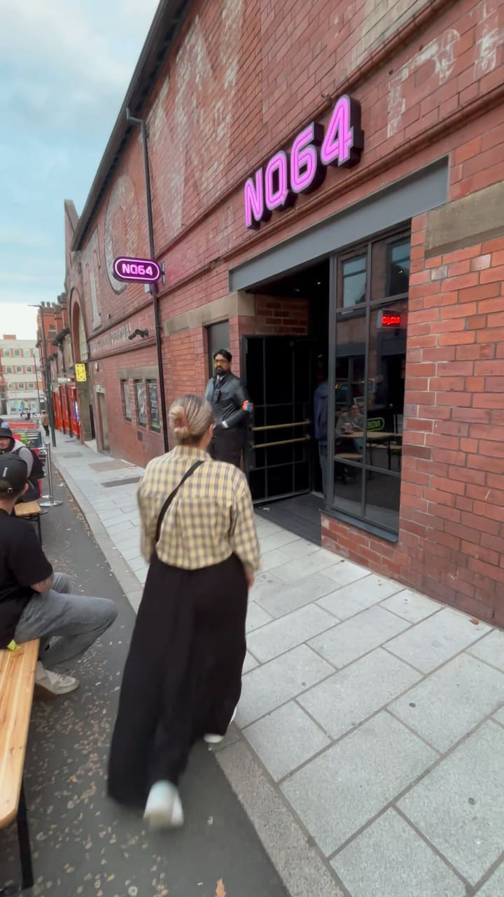 The video showcases NQ64, a gaming bar in Leeds, UK. It highlights various aspects of the bar, including its extensive drink menu (cocktails, beers), arcade games (Pac-Man, Tetris, Dance Dance Revolution), console games (Game Boy, various consoles), and a photo booth. The overall atmosphere is vibrant and nostalgic, with neon lighting and retro decor.  Drinks are shown, including cocktails and beers on tap. No specific dietary information is provided.