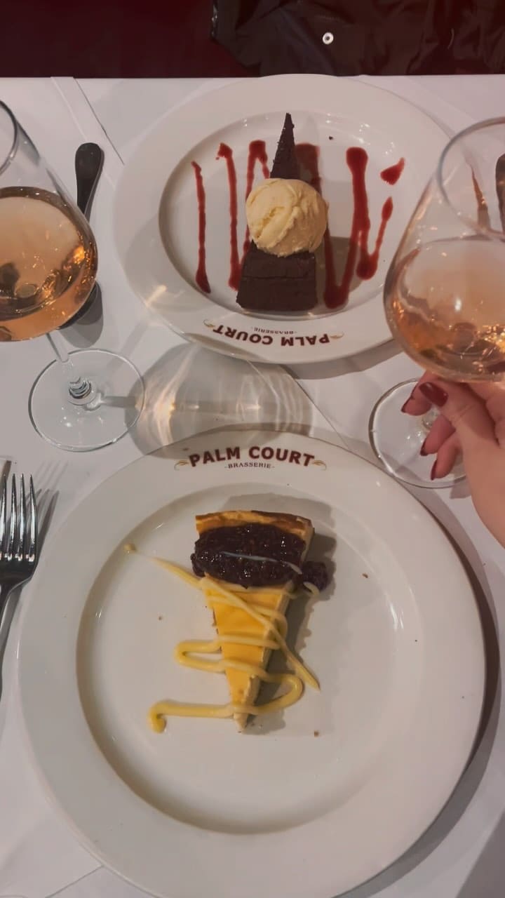 The video showcases a romantic dinner at Palm Court Brasserie in Covent Garden, London.  The video shows various dishes from their pre-theatre menu including wild mushroom soup, baked brie in filo pastry, beef bourguignon, market fish, a Belgium chocolate tart and cheesecake. The food is presented elegantly, with a focus on close-up shots highlighting textures and colors. The video also features shots of the restaurant's interior and the influencer enjoying the ambiance and the food. No dietary information is explicitly stated. The main focus is showcasing the dining experience and the food items offered.