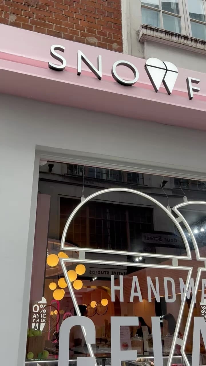 The video showcases Snowflake Gelato in Soho, London. It highlights their Iced Pistachio Latte, Lotus Biscoff Sundae Shake, and Gelato baskets with praline, salted caramel, and Kinder gelato.  The presentation emphasizes the visually appealing colors and textures of the desserts and drinks.  No specific dietary information is provided. The main focus is on showcasing the food and drink offerings and the pleasant atmosphere of the cafe.