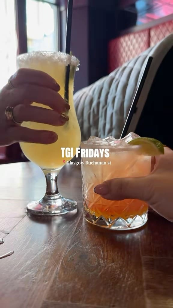 A short, energetic vlog-style video capturing a visit to TGI Fridays. The creator showcases the menu, various cocktails, chicken wings with fries, and a brownie dessert, while also including shots of themselves and their baby, highlighting the venue as a family-friendly casual dining spot.