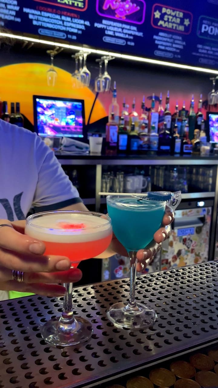 The video showcases a date night at NQ64, an arcade bar in Soho, London. It highlights the bar's atmosphere, cocktail menu (including the "Power Star Martini" and a blue cocktail), and various arcade games available, such as Pac-Man, Mario Kart, and The House of the Dead.  The video also shows the process of making cocktails at the bar and customers enjoying the games. The primary focus is on the overall experience of the arcade bar, combining drinks and classic arcade games.