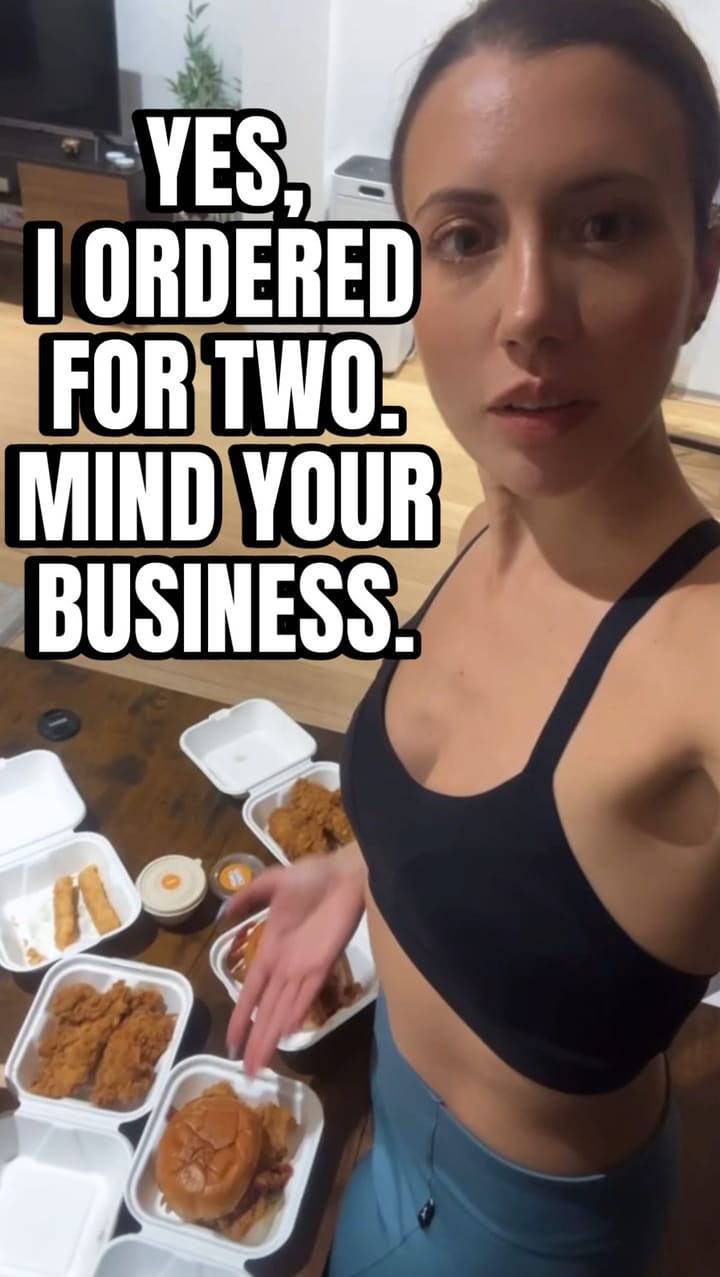 The video follows the influencer's routine of finding a new food spot near a gym class. She visits Butchies Fried Chicken, showing the exterior signage and interior counter area. The video features close-ups of various fried chicken items, including a loaded burger, chicken tenders, and fries, highlighting their appearance and her positive reaction. It shows the food being prepared and packaged for takeaway. The influencer takes the food home and shows it laid out, dipping tenders in sauce and showcasing the burger. The video ends with her dogs looking at the food bag.